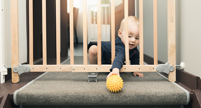 baby reaching through baby gate