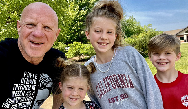 Mike King and grandkids smiling for a photo during their family history pilgrimage