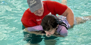 Swim instructor works with Argentine student during swim lessons